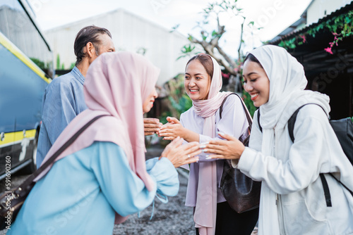 portrait of muslim family taking their parent to the bus station and shake hand goodbye