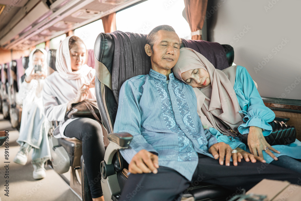 mature man and woman take a nap during road trip on the bus