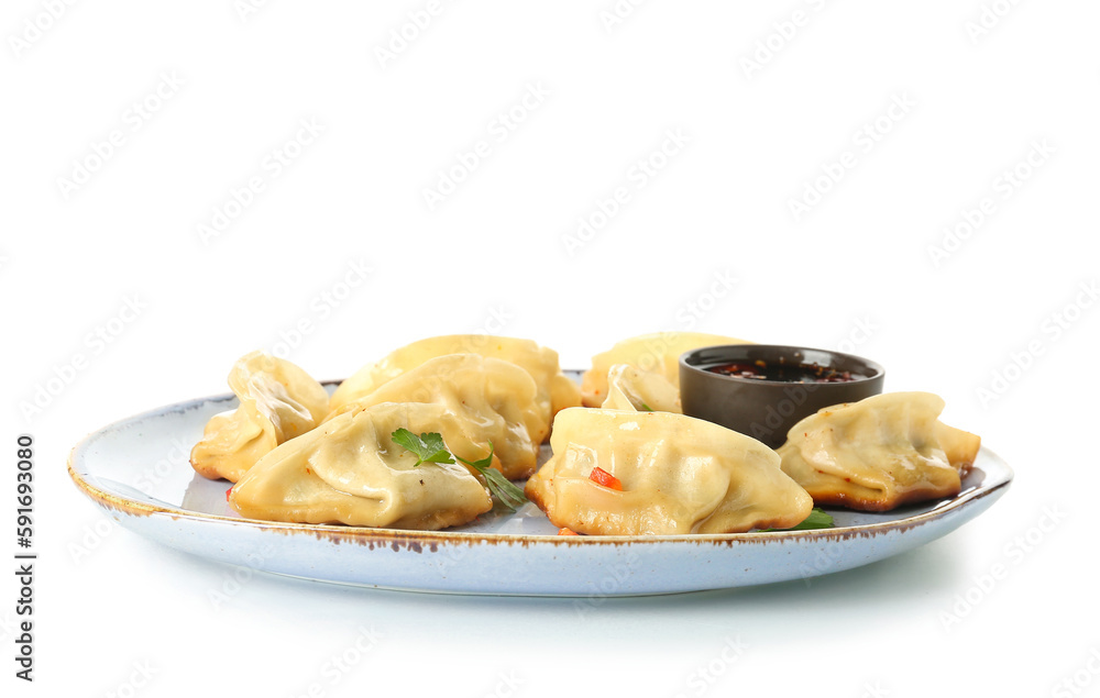 Plate with tasty Chinese jiaozi, parsley and sauce on white background Plate with tasty Chinese jiaozi, parsley and sauce on white background