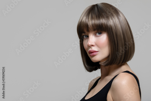 Fotobehang Portrait of a beautiful brown-haired woman holding with shiny short hair