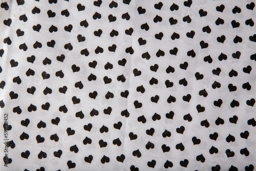 White fabric with black hearts design print. Background.