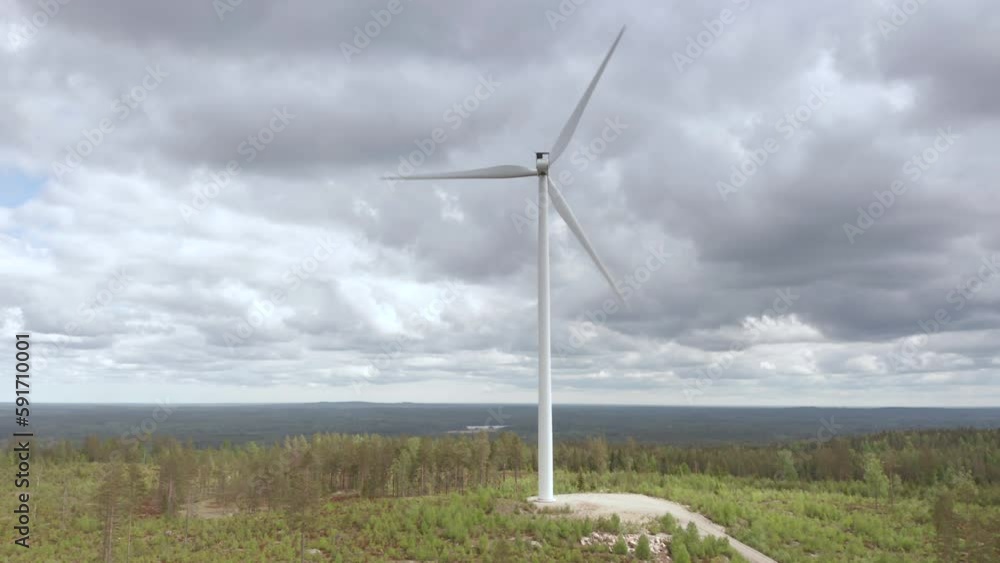Aerial arc shot of wind turbine rotating against overcast sky. Remote country Aerial arc shot of wind turbine rotating against overcast sky. Remote country