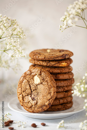 A stack of chocolate chip and coffee flavoured cookies with one leaning against the side of the stack. of coffee cookies wi photo