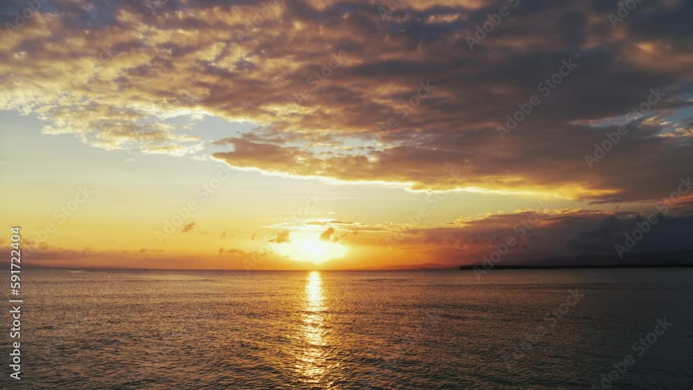 The sun touches the horizon. Sea sunset background, view from the beach. Sunset in blue sky with orange clouds over the Caribbean Sea. Nice summer seascape. Evening sun glare on the water. The sun touches the horizon. Sea sunset background, view from the beach. Sunset in blue sky with orange clouds over the Caribbean Sea. Nice summer seascape. Evening sun glare on the water.