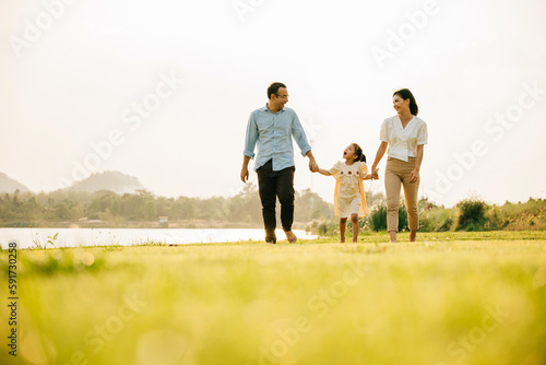 Photography A young kid girl and her parents walking and playing in a scenic garden on a sun