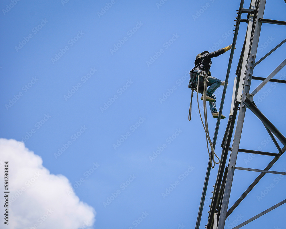 lineman climbing on transmission line tower lineman climbing on transmission line tower