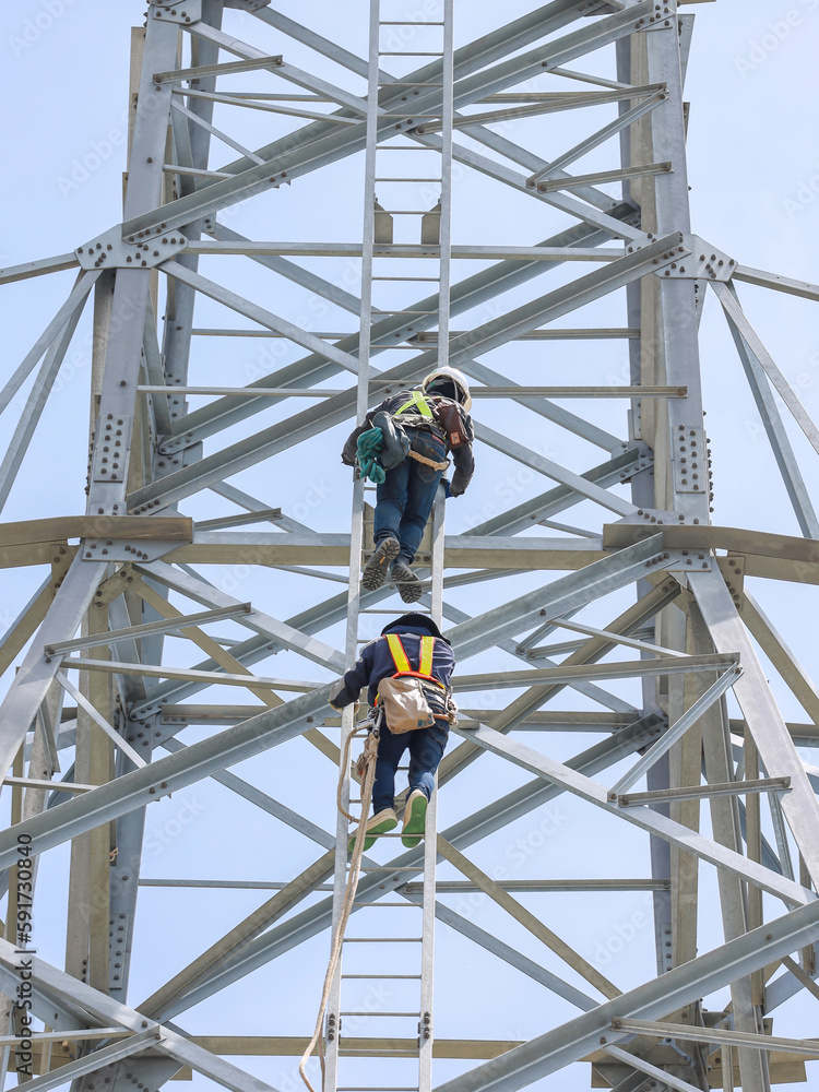 lineman climbing on transmission line tower