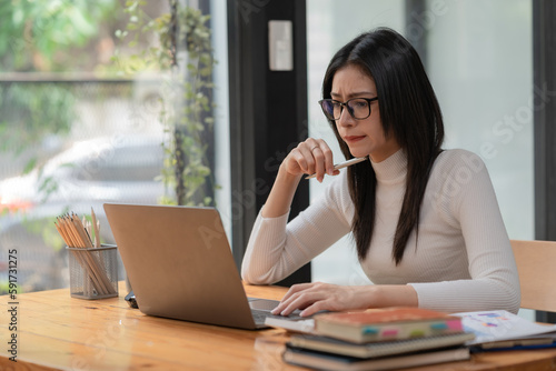 Quadro em tela Concerned female worker looking at laptop screen suspiciously, thinking about problem-solving, reading ambiguous emails or negative news