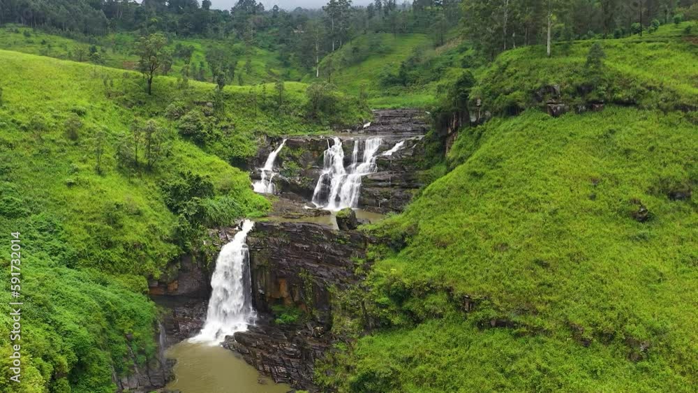 Aerial view of waterfall among green hills with tea plantations. St. Clair Falls, Sri Lanka. Tea estate landscape. Aerial view of waterfall among green hills with tea plantations. St. Clair Falls, Sri Lanka. Tea estate landscape.