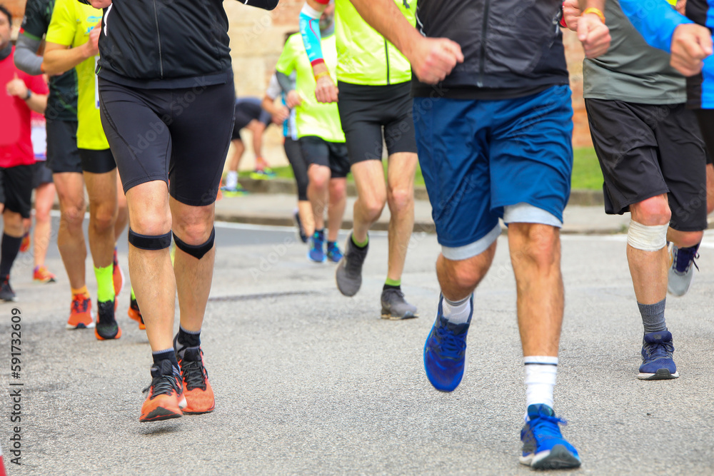 athletes with sports clothes run during the running race in the paved road in the city athletes with sports clothes run during the running race in the paved road in the city