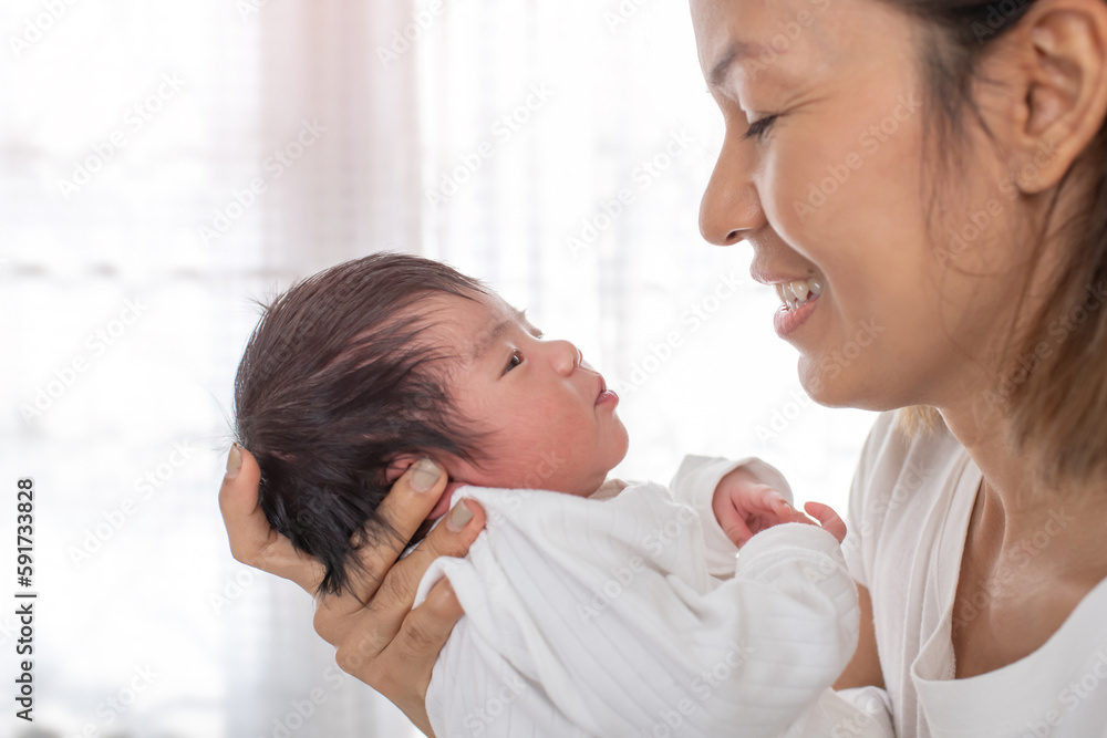 happy loving family. mother playing with her baby hugging in the bedroom , portrait of asian mother playing with newborn baby, health care family love together. asian girl lifestyle.. happy loving family. mother playing with her baby hugging in the bedroom , portrait of asian mother playing with newborn baby, health care family love together. asian girl lifestyle..