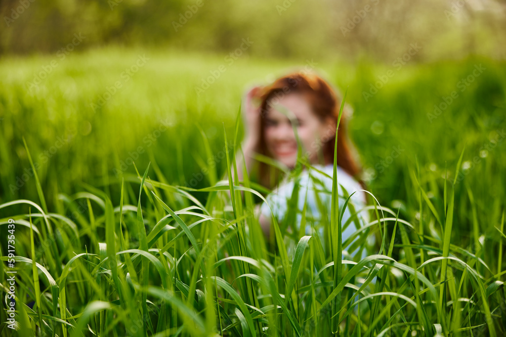 photograph of a woman sitting in the grass focusing on grass leaves photograph of a woman sitting in the grass focusing on grass leaves
