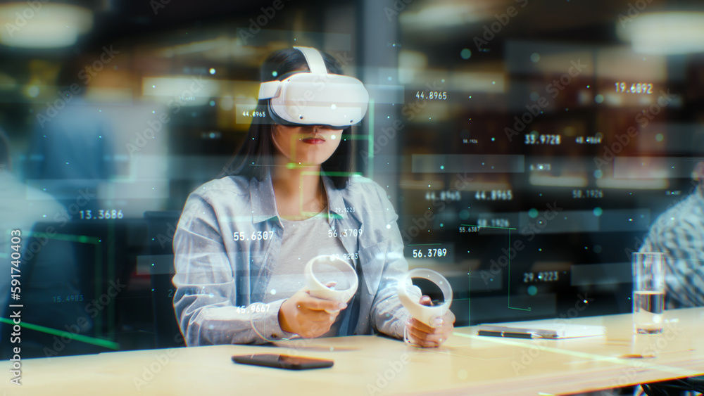 Female office worker uses VR headset and wireless controllers, watches data and numbers in 3D virtual reality. Asian woman works in modern hi-tech IT company. Future innovative digital technologies. Female office worker uses VR headset and wireless controllers, watches data and numbers in 3D virtual reality. Asian woman works in modern hi-tech IT company. Future innovative digital technologies.