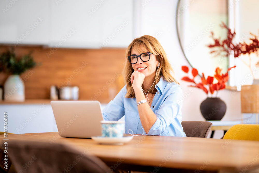 Attractive woman with earphones usig laptop for work at home Attractive woman with earphones usig laptop for work at home