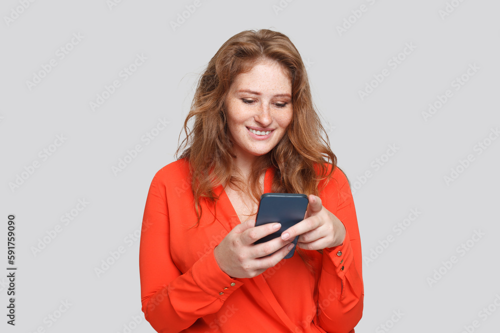 Happy smiling woman using smartphone, studio portrait Happy smiling woman using smartphone, studio portrait