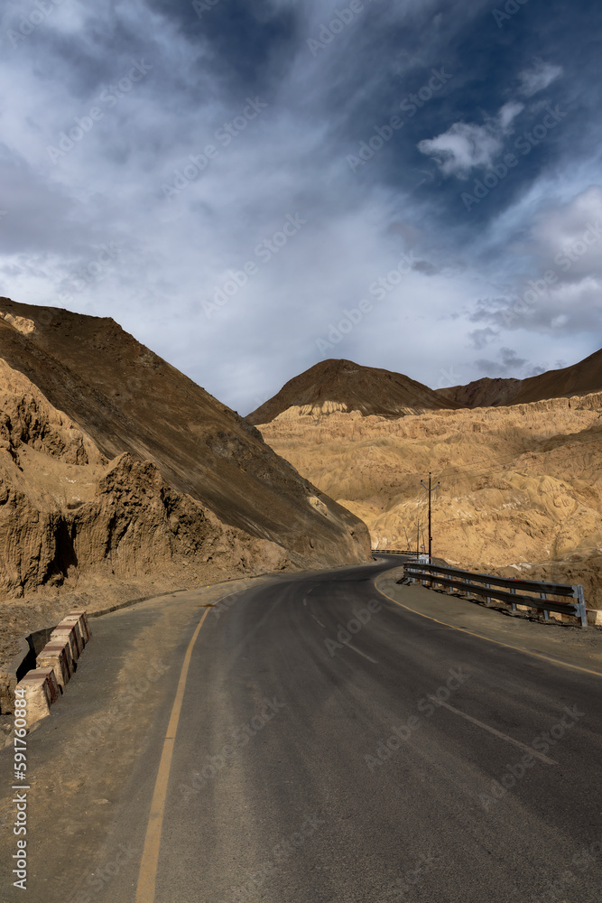Curvy metal road winds through stunning Moonland Mountains in Ladakh near Lamayuru, offering breathtaking views.