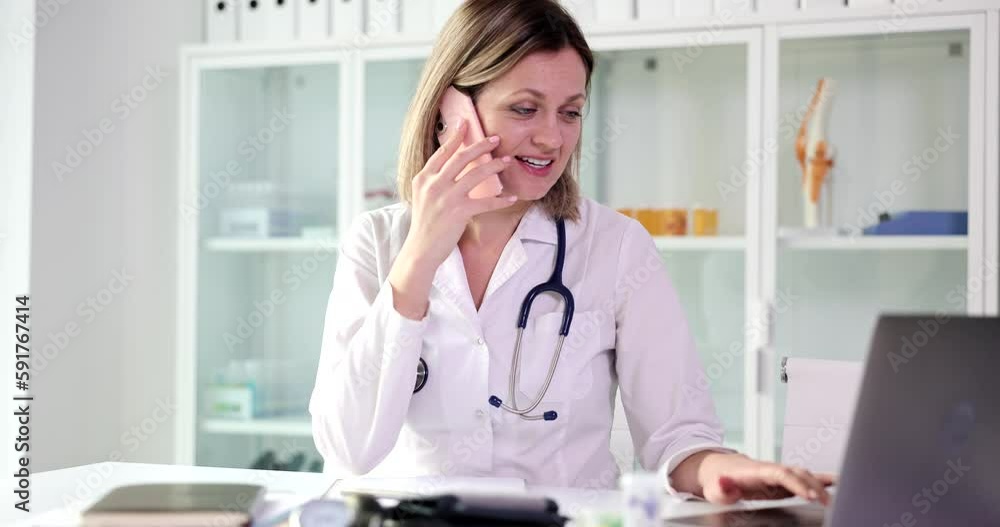 Positive woman doctor talks with patient on phone checking treatment plan on laptop. Experienced specialist gives recommendations remotely Positive woman doctor talks with patient on phone checking treatment plan on laptop. Experienced specialist gives recommendations remotely