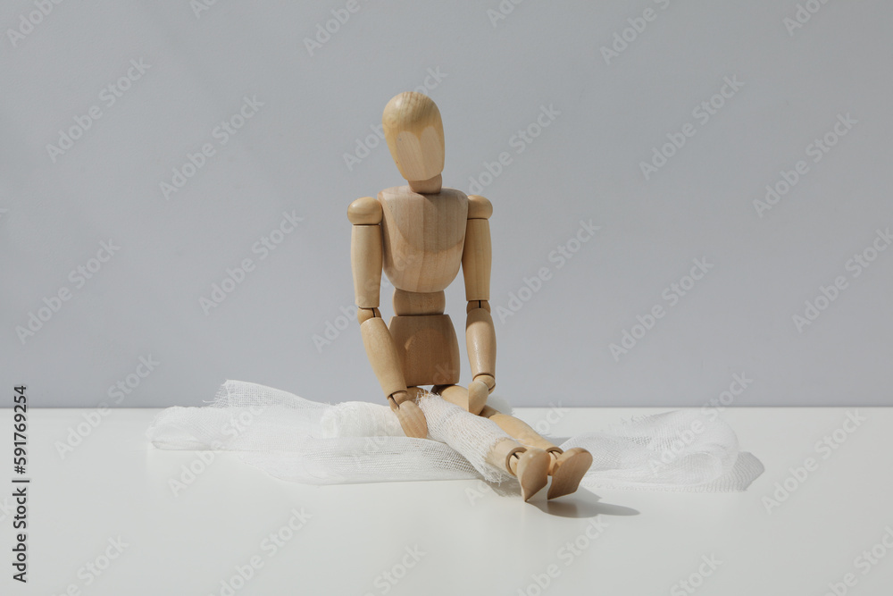 Concept of injury with wooden puppet with bandage Concept of injury with wooden puppet with bandage