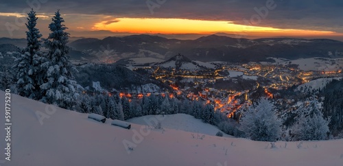 Panorama winter old City. Banska Stiavnica, Slovakia. Church at the top of the hill. Light of houses in the valley photo