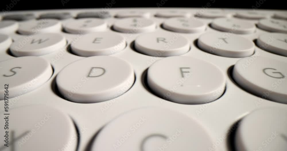 Detailed buttons of modern white keyboard on computer on office table. Wireless input device designed for typing text on black background macro Detailed buttons of modern white keyboard on computer on office table. Wireless input device designed for typing text on black background macro