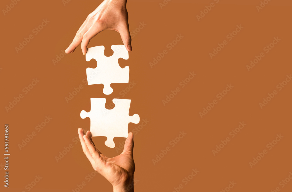 Two hands trying to connect couple puzzle with yellow background. Hand ...