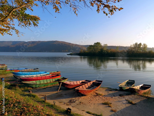 Boats on the bank of the river on sunny day in autumn