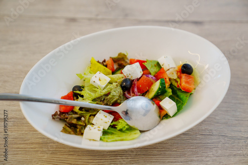 Greek salad in a white plate. dish for the menu of a cafe or restaurant.