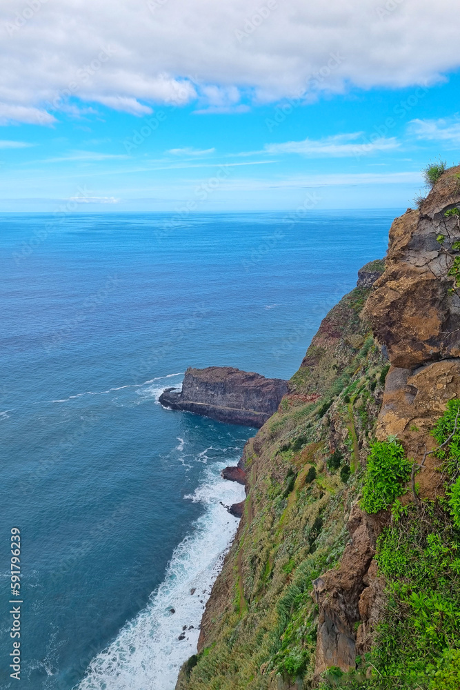 A picturesque cliff from the island of Madeira and a view of the ocean.