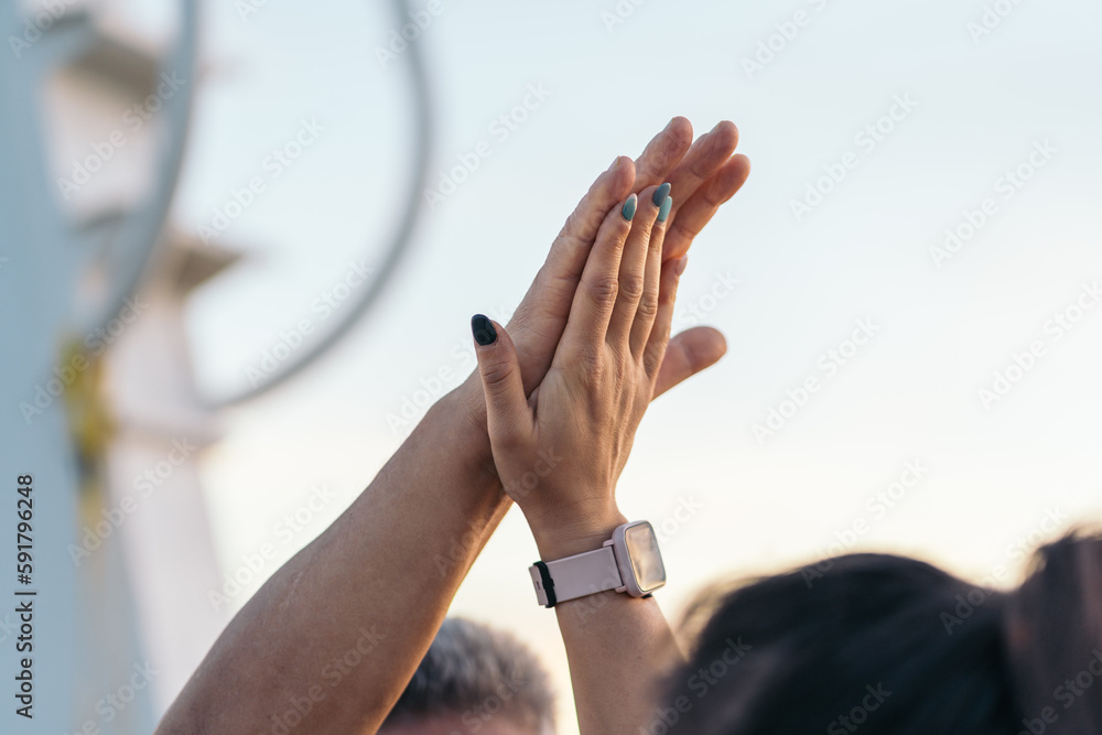 Close-up of a high-five at sunset time.. Close-up of a high-five at sunset time..