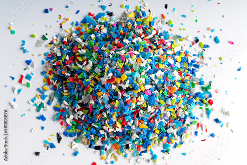Small pieces of crushed plastic. Crushed bottle caps for recycling. Plastic waste that will be mixed with plastic vergin. Concept reducing plastic.