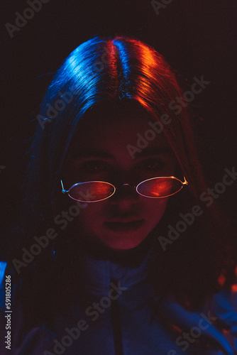 stylized portrait of a young girl with modern glasses using 2 sources of colored light