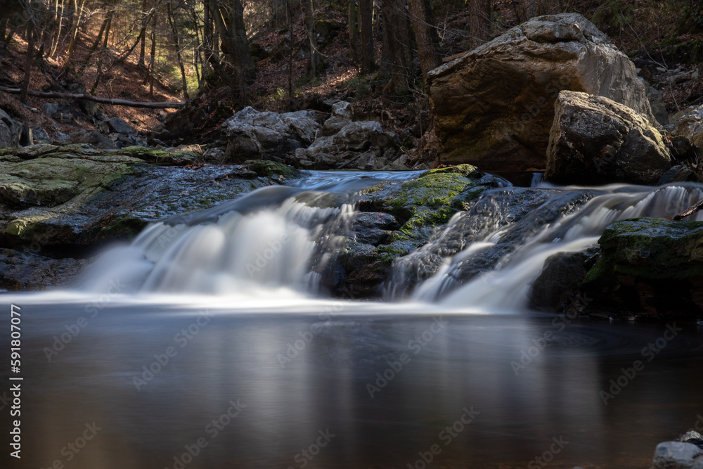 Small waterfall with sunlight in forest