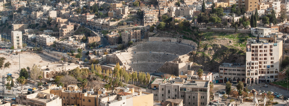 Famous landmark of capital of Jordan. Amman Roman Theater of  2nd century. Philadelphia. Amman city with residential areas around amphitheater. Jordan, Amman - December 02, 2009