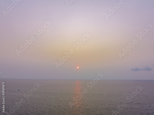 aerial view the sun going down to the horizon in sweet sunset above coconut trees..Nature High quality Scene of Colorful romantic sky sunset with cloud in the sky background .for creative nature  © Narong Niemhom