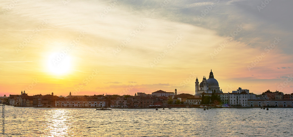 Beautiful bright sunset sky over the water and skyline of Venice, Italy