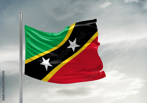 Saint Kitts national flag cloth fabric waving on beautiful sky Background.