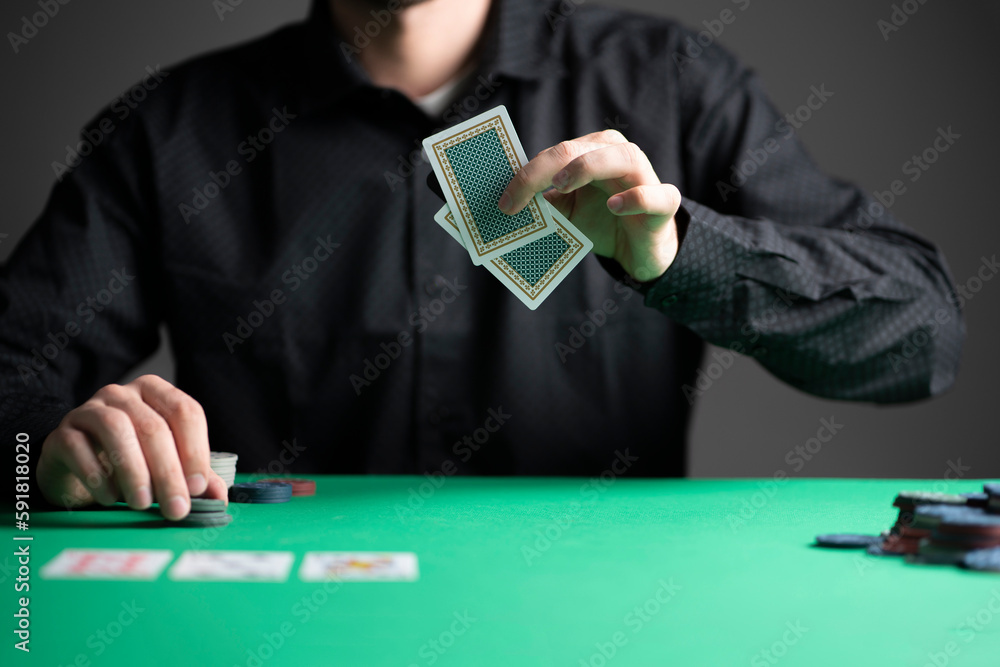 poker player in the casino playing a game and holding cards poker player in the casino playing a game and holding cards