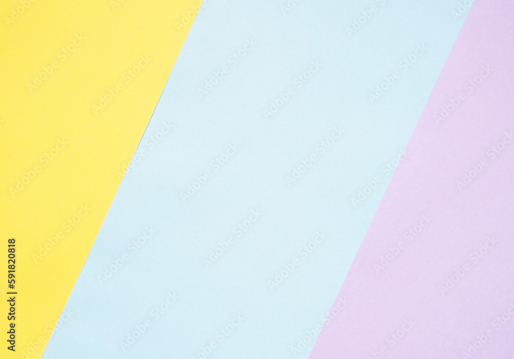 Colored paper is laid out diagonally. Yellow, blue and purple colored paper. Abstraction, background Colored paper is laid out diagonally. Yellow, blue and purple colored paper. Abstraction, background