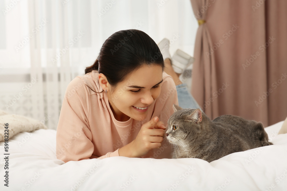 Young woman with adorable cat at home Young woman with adorable cat at home