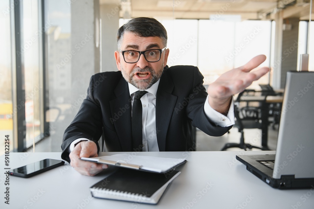Fototapeta premium Angry businessman with document shouting at somebody