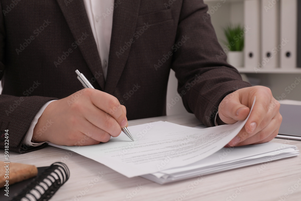 Man signing document at wooden table, closeup Man signing document at wooden table, closeup
