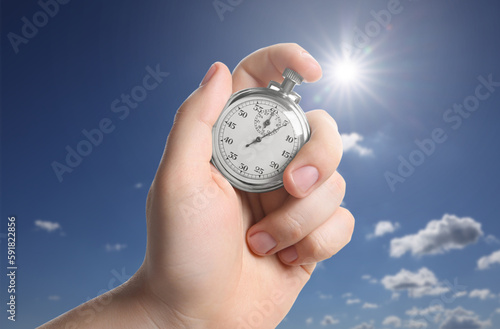 Fototapeta Naklejka Na Ścianę i Meble -  Man holding timer against beautiful sky, closeup. Space for text