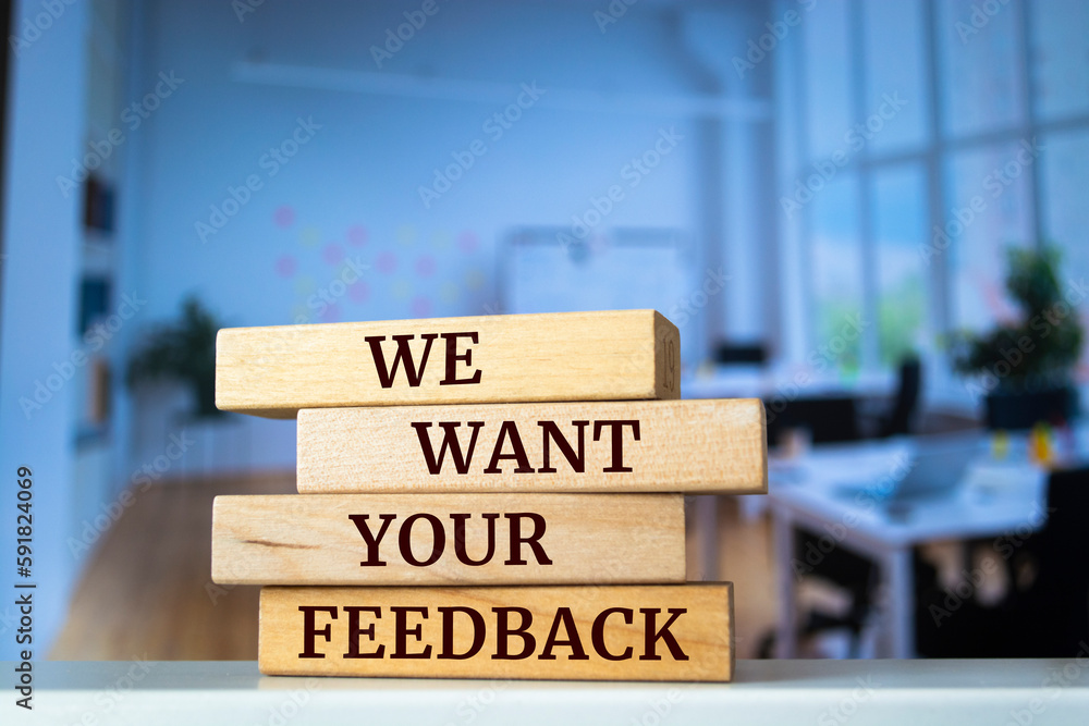 Wooden blocks with words 'WE WANT YOUR FEEDBACK'. Business concept