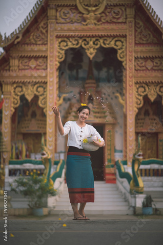 Songkran day with women in traditional Thai dress. © Supat