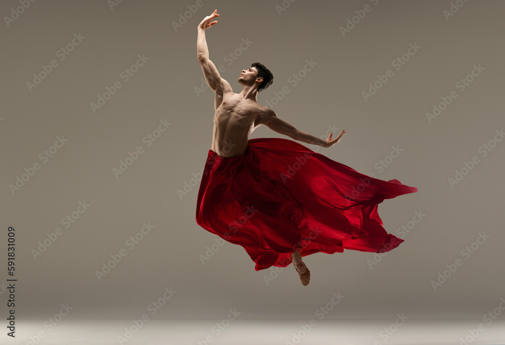Young, athletic, handsome man, ballet dancer making performance with red silk fabric against grey studio background. Concept of art, classical dance, inspiration, creativity, beauty, choreography - obrazy, fototapety, plakaty 