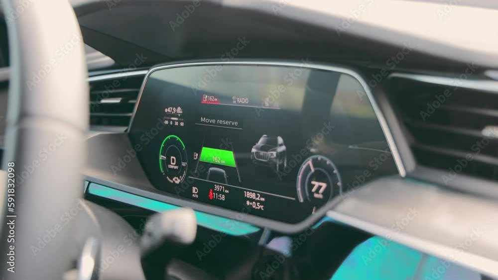 Dashboard of an electric car while driving. Speedometer and tachometer with information about the movement of the car. Dashboard of an electric car while driving. Speedometer and tachometer with information about the movement of the car.