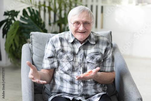 Foto Portrait of Funny retired man with denture looking at the camera and smiling