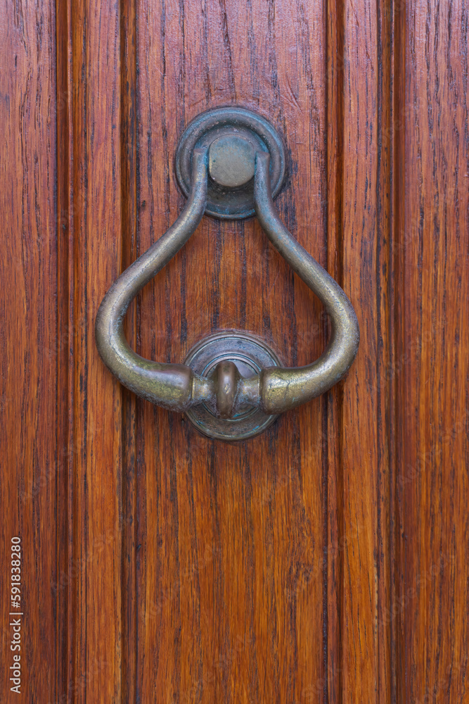 Antique metal door knocker on a wooden door