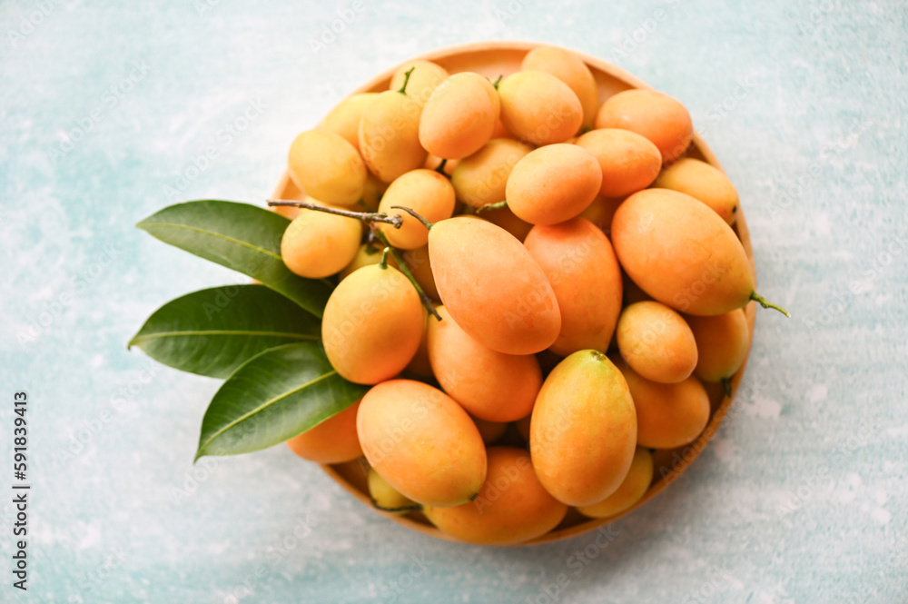 Marian plum fruit and leaves in plate on wooden background, tropical fruit Name in Thailand Sweet Yellow Marian Plum Maprang Plango or Mayong chid Marian plum fruit and leaves in plate on wooden background, tropical fruit Name in Thailand Sweet Yellow Marian Plum Maprang Plango or Mayong chid