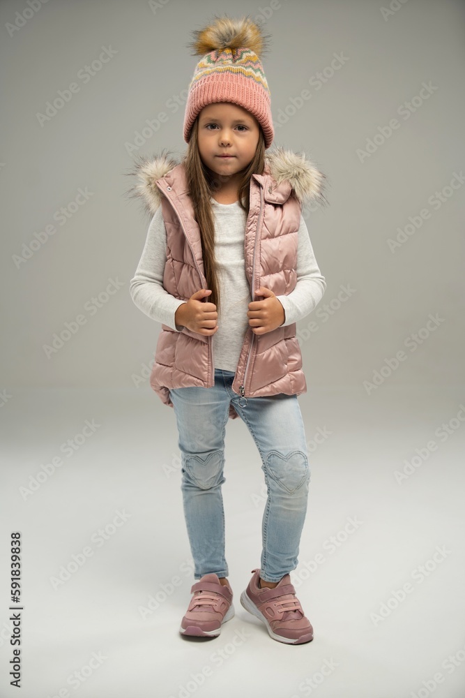 Full length of little girl, child, posing in warm jacket and hat isolated over white background. Copy space for ad Full length of little girl, child, posing in warm jacket and hat isolated over white background. Copy space for ad